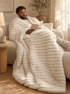 Man reading on the sofa under the Stretch Plush blanket